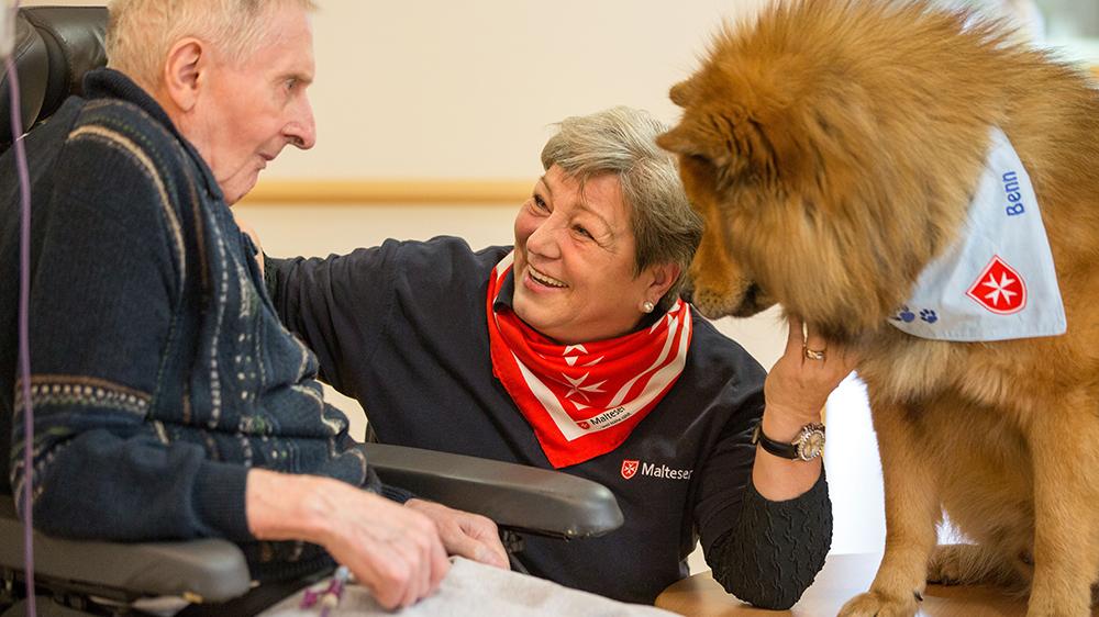 Besuchshund "Benn" begrüßt einen älteren Herrn